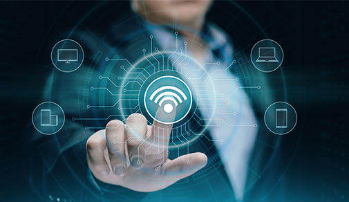 A person's finger touches a glowing holographic Wi-Fi symbol, which is centrally connected to various device icons